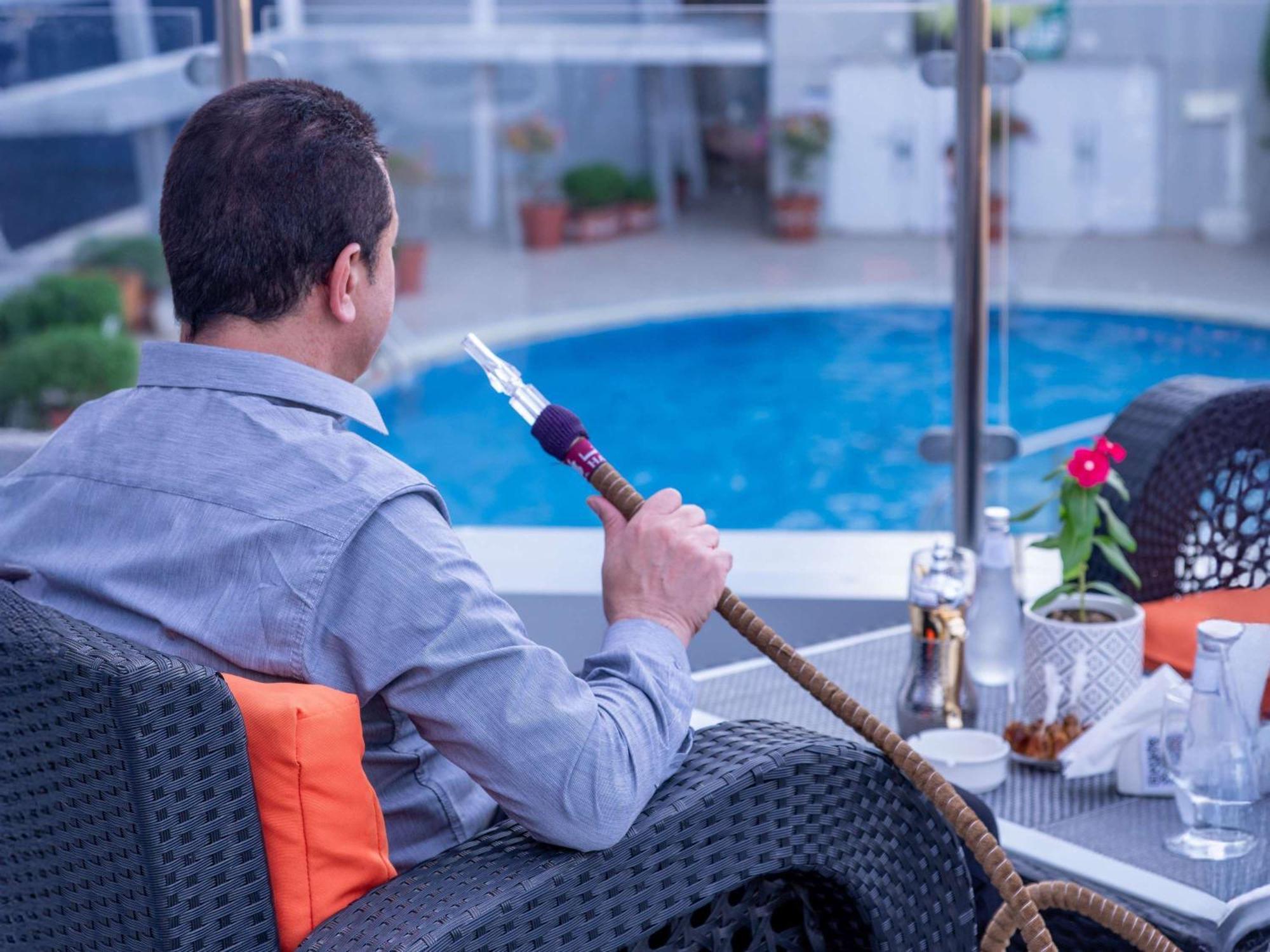 Novotel Jazan Exterior photo A man smoking a hookah
